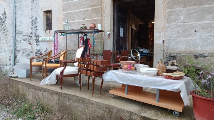 Notre entrée Mobilier et objets divers exposés devant un bâtiment ancien.