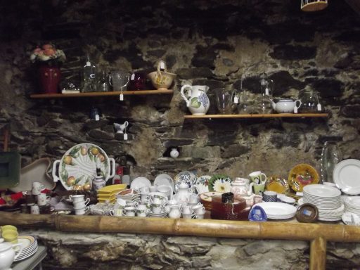 tasses et autre vintage Vaisselier rustique en pierre avec vaisselle ancienne et objets décoratifs.